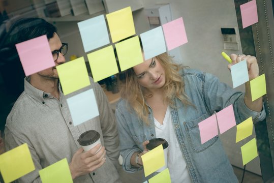 Business colleagues writing on sticky notes