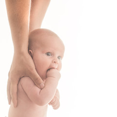 Baby stands with parents support.