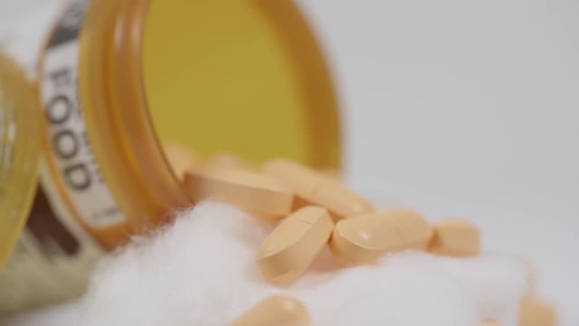 Close up macro of drugs spilling out of a prescription bottle