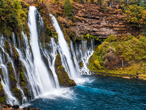 Fototapeta Picturesque waterfall cascade in autumn, surrounded by the moss and yellow bushes. Shot taken in October at McArthur-Burney Falls Memorial State Park, in Shasta County, Northern California.