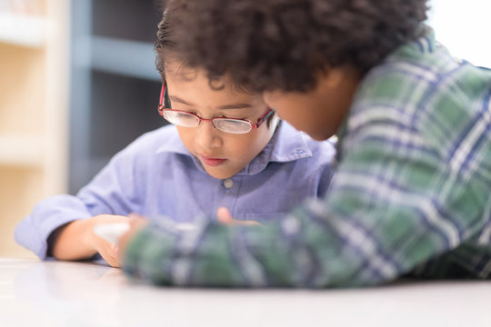 In selective focus of little boys watching Phone. Happy Children Learning Class in Library. Development of Human Resources in Education Concept. Setup studio shooting.