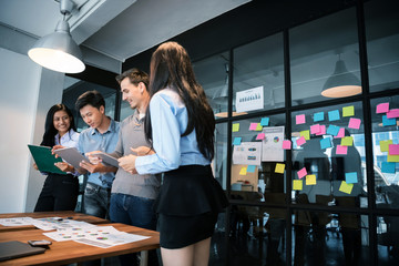 Young modern people in casual wear planning business strategy. Business team analyzing income charts and graphs. Setup studio shooting.