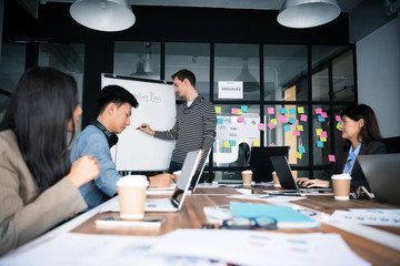 Young modern people in casual wear planning business strategy.Business team analyzing income charts and graphs. Setup studio shooting.