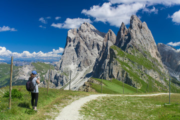 Fototapeta premium girl taking photos in beautiful summer landscape. Seceda Odle mountain in Italy Dolomites