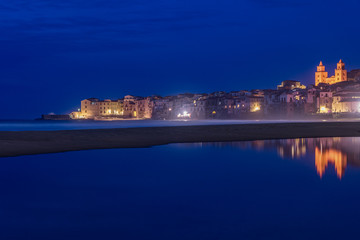 Fototapeta na wymiar Il pittoresco borgo marinaro di Cefalù riflesso sull'acqua di notte, Sicilia 