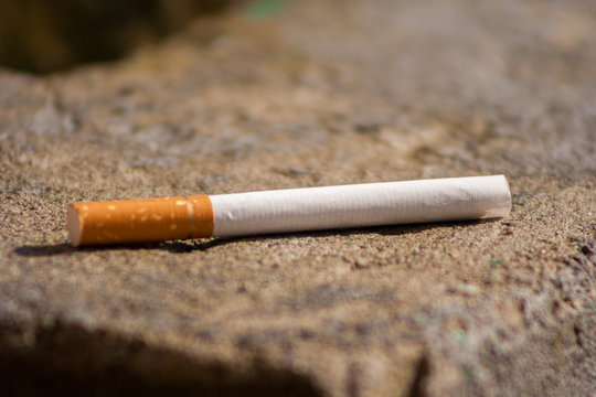 Photo of a cigarette lying on concrete