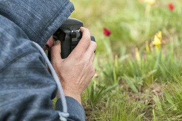 Young male photographer taking photo by DSLR camera. Nature and landscape photography