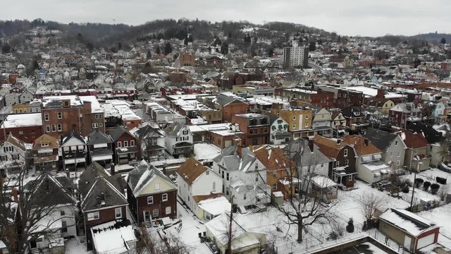 A slow forward aerial establishing shot of a small northeastern rust belt American village in the winter. Pittsburgh suburbs.  	