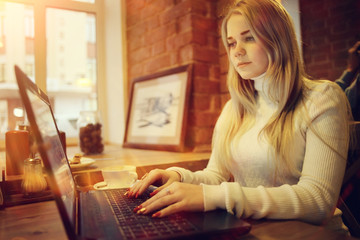 young woman working on laptop in cafe, concept of remote work, training, student preparing for exams, girl with gadget in restaurant