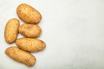 Potato tubers on a white vintage background. Copy space for text.