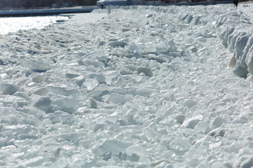 Beautiful nature. Ice shiny cubes on the shoreline of a frozen sea or ocean on a cold, frosty winter day