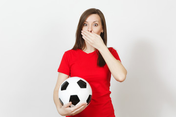 Beautiful European young woman, football fan or player in red uniform cover mouth with hand, hold soccer ball isolated on white background. Sport, play football, health, healthy lifestyle concept.