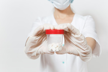 Close up cropped shot of young doctor woman isolated on white background. Female doctor in medical uniform, gloves pointing on bottle with pills. Healthcare personnel, medicine concept. Copy space.