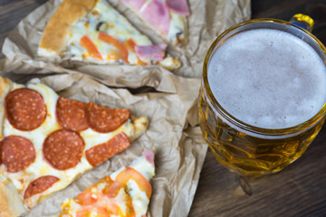 Light beer in glass and fragrant Italian pizza.