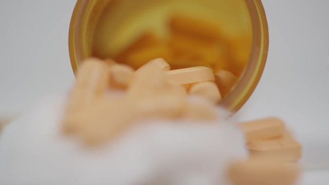 Close up macro of drugs spilling out of a prescription bottle