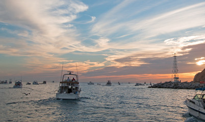 Fishermans sunrise view of fishing boat going out for the day past Lands End in Cabo San Lucas in Baja Mexico