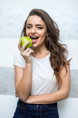 The young beautiful woman eat apple at home