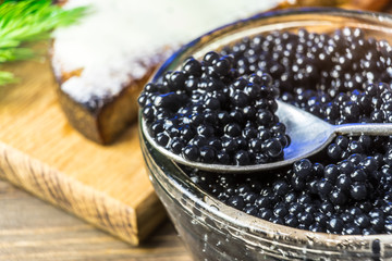 Black caviar on a sandwich. Put a silver spoon on the sandwich.