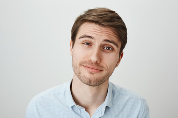 Studio portrait of attractive pleasant male office worker with tired expression, feeling sorry for...