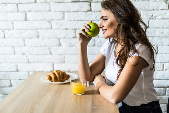 Young woman having breakfast at home, eating healthy food.