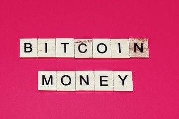 Wooden blocks on a red background spelling words Bitcoin money