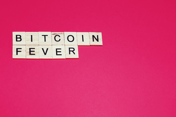Wooden blocks on a red background spelling words Bitcoin fever