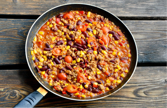 Chili con carne in pan on wooden floor