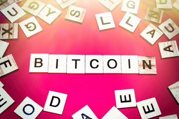 Wooden blocks on a red background spelling word Bitcoin