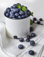 Frische Blaubeeren / Heidelbeeren in einem weißen Topf auf einer Serviette