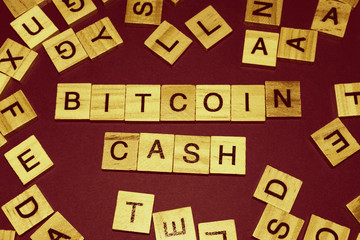 Wooden blocks on a brown background spelling words Bitcoin Cash