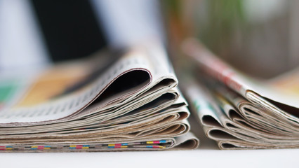 Newspapers on horizontal surface, daily papers with news. Selective focus, side view