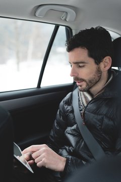 Man using digital tablet in a car