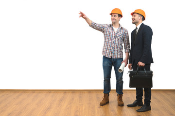 The two happy engineers gesture on the white wall background