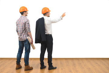 The engineer and a businessman gesture on the white wall background