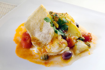Grilled cod with the addition of tomato olives and capers.