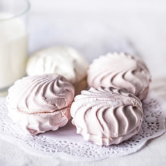 marshmallow and glass of milk on light background