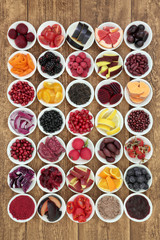 Large healthy food collection with super health promoting properties with foods very high in anthocyanins, antioxidants, protein, minerals and vitamins, on rustic background top view.