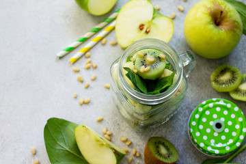 Ingredients for the preparation of green smoothies - apple, kiwi, spinach, pine nuts. Healthy vegan food concept. Copy space.