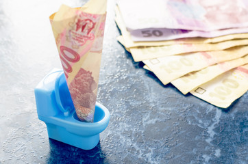 One hundred Ukrainian hryvnia in a blue toy toilet