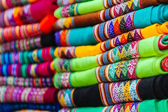 Macro close-up of colorful blankets stacked with Andean designs
