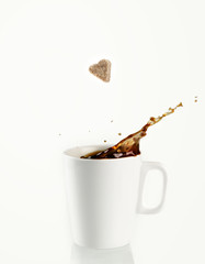 Sugar heart being dropped into coffee creating splash