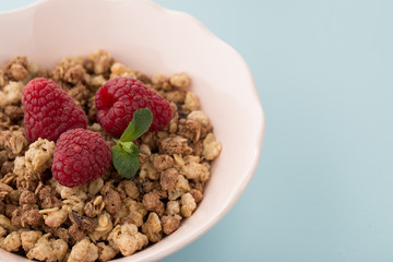 Muesli with raspberries on the blue background 
