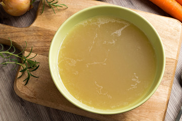 Chicken stock in a green soup bowl