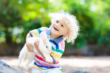 Child with rabbit. Easter bunny. Kids and pets.
