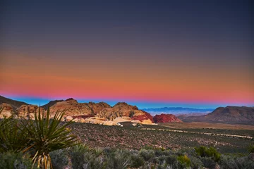 Foto op Plexiglas sun setting over redrock canyon rocks with las vegas in background © Joshua Resnick