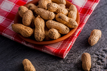 Peanuts in nutshell on a piece of wood