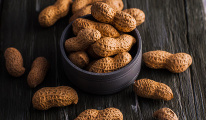 Peanuts in nutshell on a piece of wood