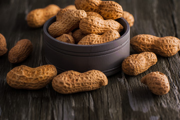 Peanuts in nutshell on a piece of wood