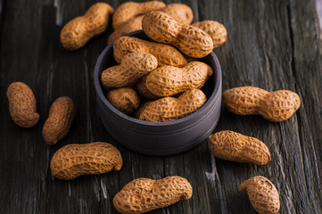 Peanuts in nutshell on a piece of wood