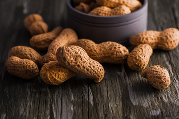 Peanuts in nutshell on a piece of wood